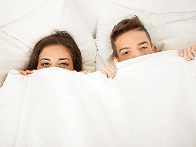 Couple Laying in Cali King Size Bed